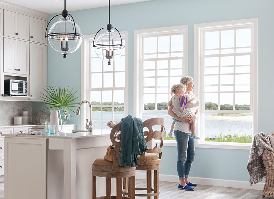 woman holding girl by windows