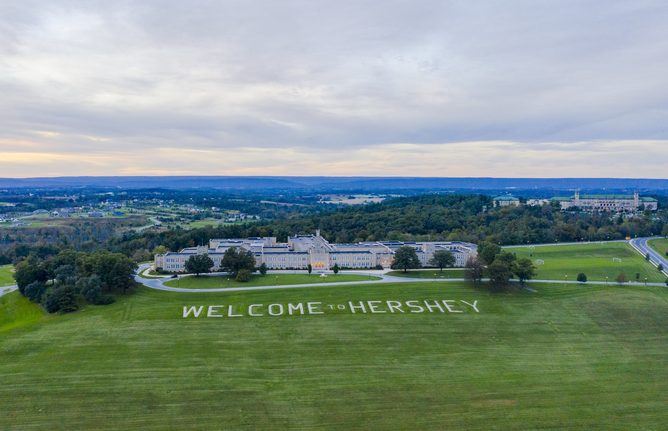 Hershey building with welcome to Hershey sign on grass