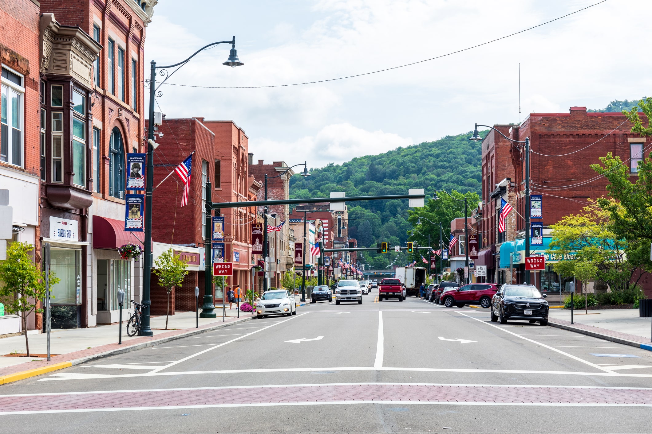 town with trees in the background and cars driving on road