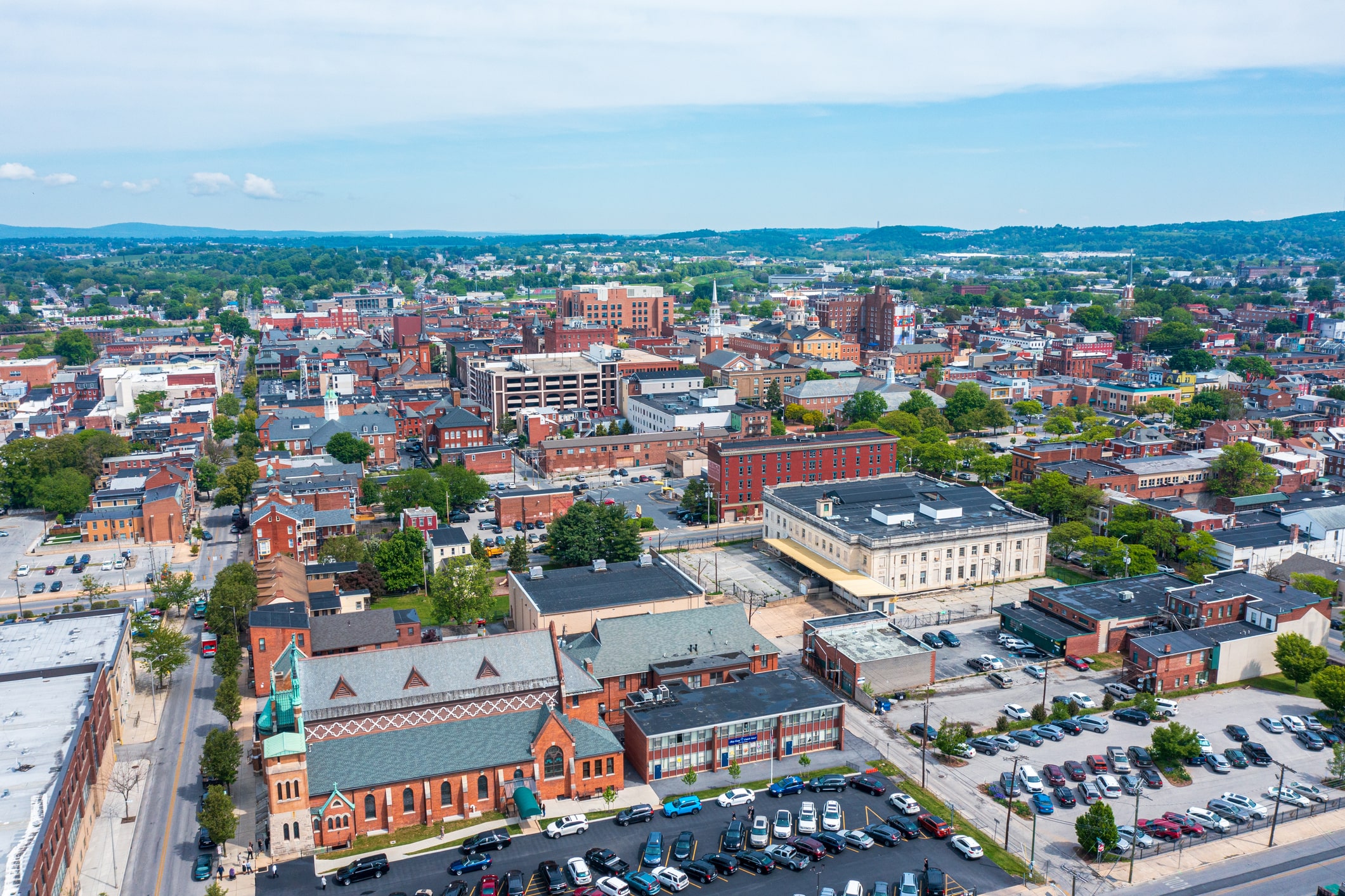 town filled with red buildings and cars parked in parking lot